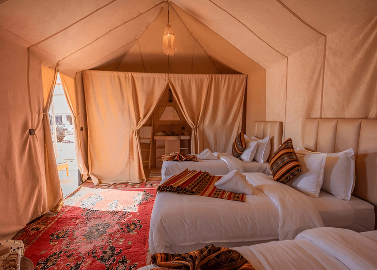 Luxury desert camp tent with comfortable beds and traditional Moroccan decor during the 2-Day Desert Adventure Zagora.
