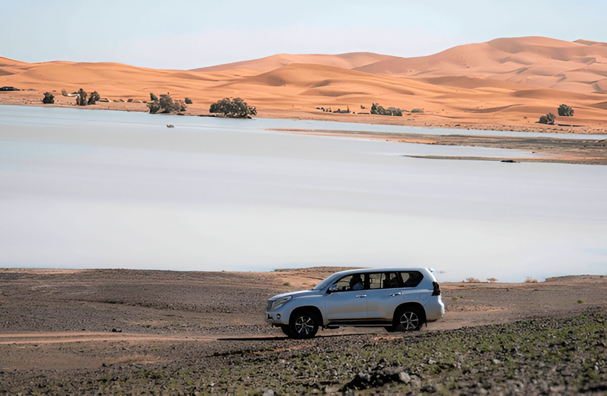 4x4 vehicle driving across the big dunes of Erg Chigaga Sahara Desert on a day trip from Zagora Morocco
