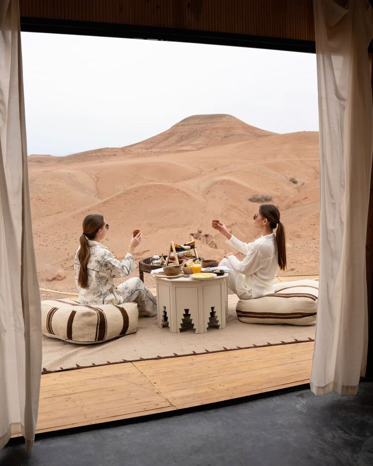 Two women enjoying breakfast in a luxury desert camp in Zagora, Morocco
