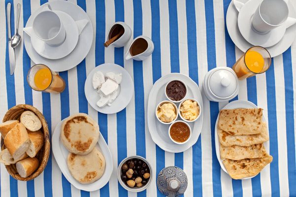 Guests enjoying a traditional Moroccan breakfast at Zagora desert camp during the 2-Day Zagora Desert Tour from Marrakech