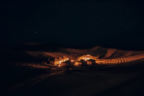 Luxury desert camp illuminated at night in Erg Lihoudi during a 2-day Marrakech desert tour