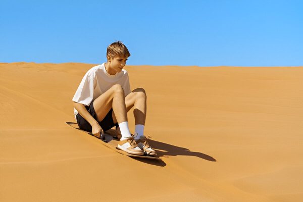Sandboarding on the dunes of Erg Lihoudi during a 2-day Marrakech desert tour