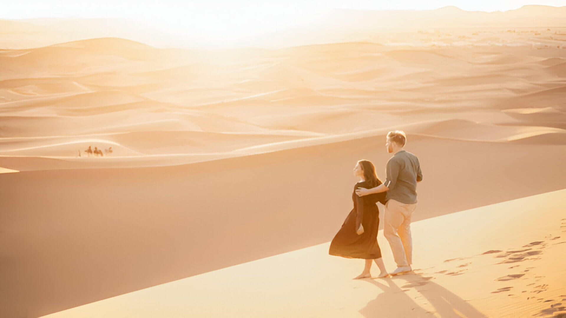 Couple walking in the Sahara desert dunes of Erg Chebbi during a private desert tour from Marrakech