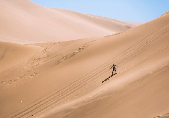 Sandboarding in Erg Chigaga desert dunes during a 2-day Sahara tour from Ouarzazate