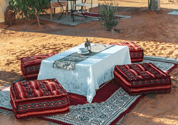 romantic luxury desert camp in Merzouga Sahara with candles and tents under stars
