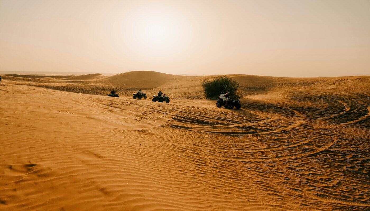 Guests riding quad bikes in the Sahara dunes during a 3-day shared Marrakech to Fes desert tour