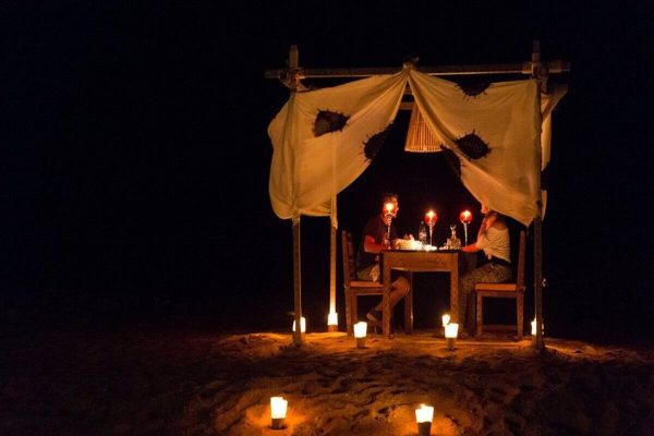 Couple enjoying a romantic dinner at a luxury desert camp in Zagora