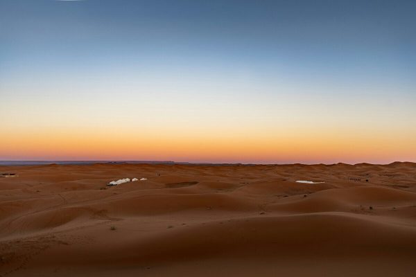 Desert camp surrounded by remote Sahara dunes in Erg Chigaga, Morocco