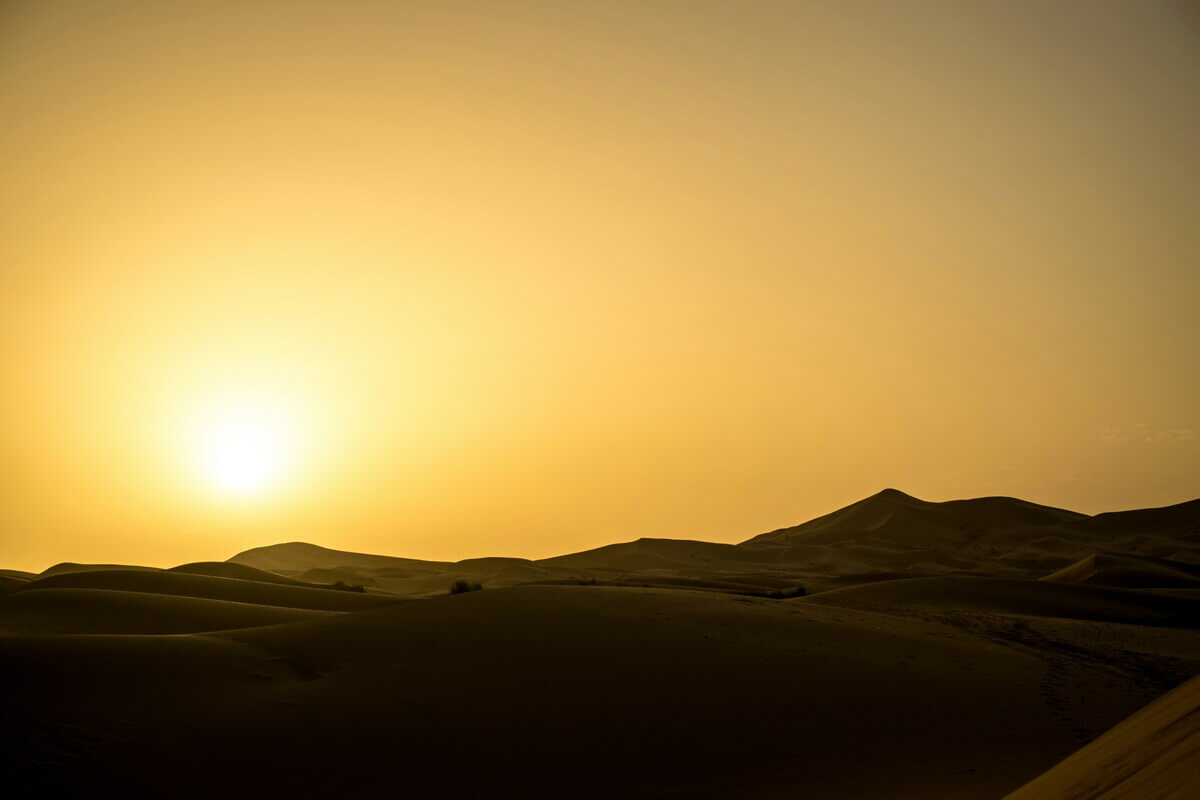 Erg Lihoudi dunes and desert camp at sunset in Morocco