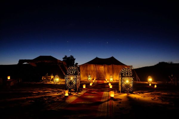 Luxury desert camp in Morocco illuminated by lanterns at night
