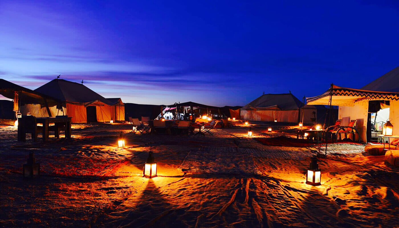 Luxury desert camp in Merzouga surrounded by the golden Erg Chebbi dunes